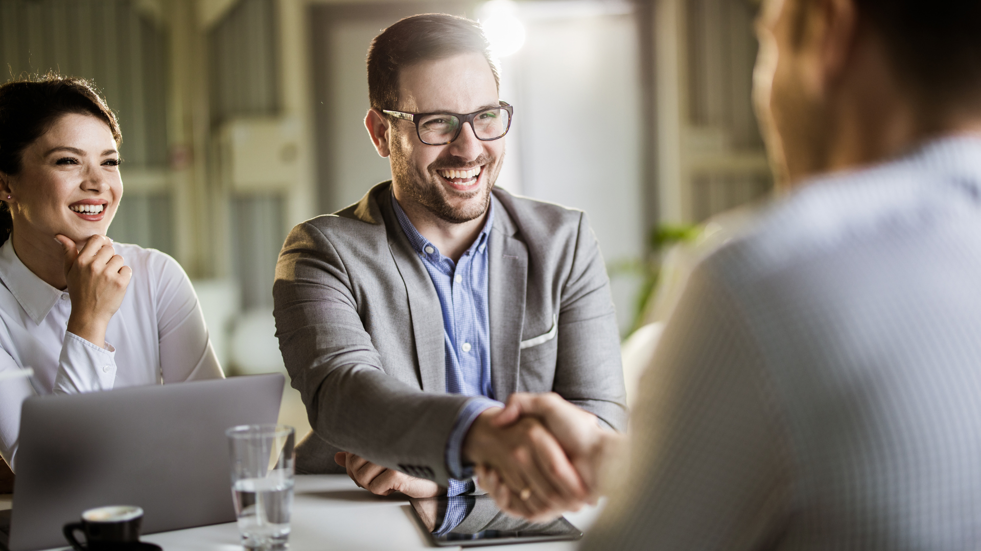 Business professionals negotiating a merger deal with Meritus Group's advisory